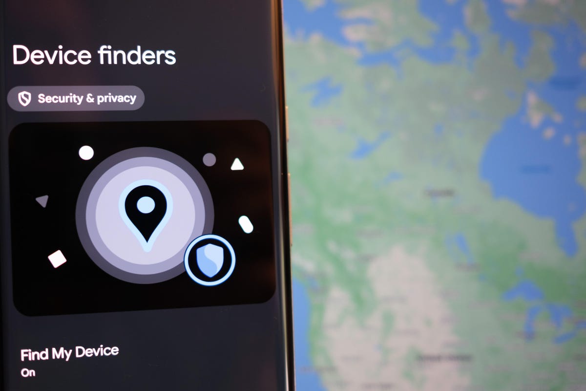 Android phone with the Device finders setting open. In the background is a map from Google's Find My Device service.